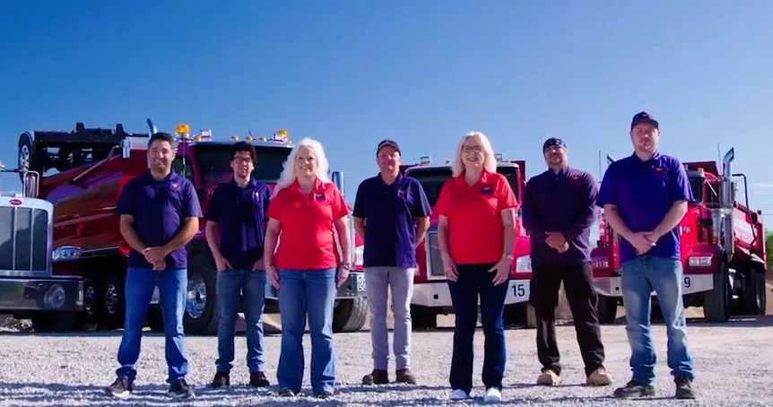 The family-owned Arizona Trucking & Materials team standing in front of the dump truck fleet