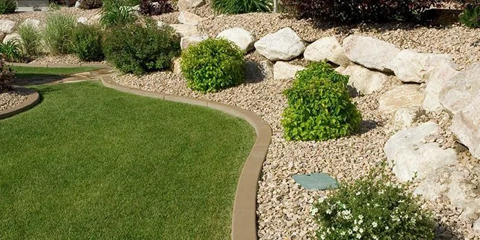 Landscaped yard with decorative rock, lawn and shrubs